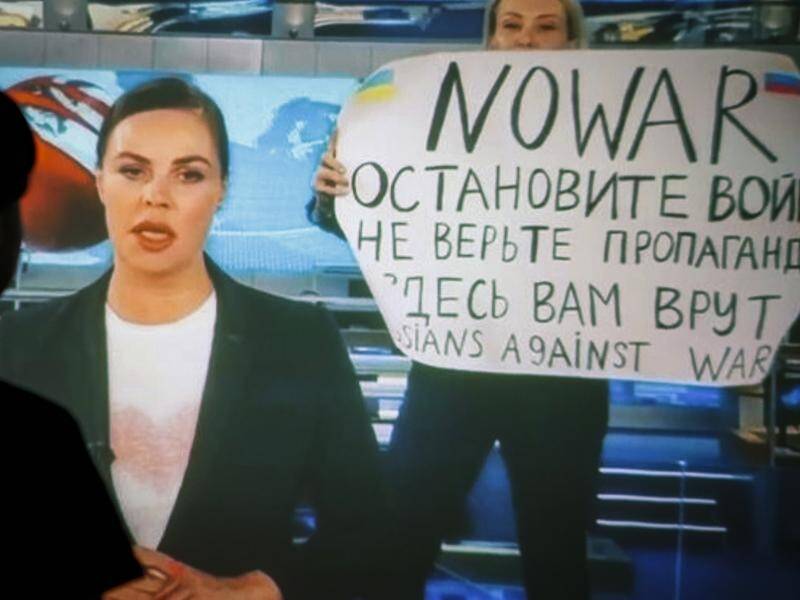 Marina Ovsyannikova appeared behind a TV news presenter with a "Stop the war" sign in March 2022. (EPA PHOTO)